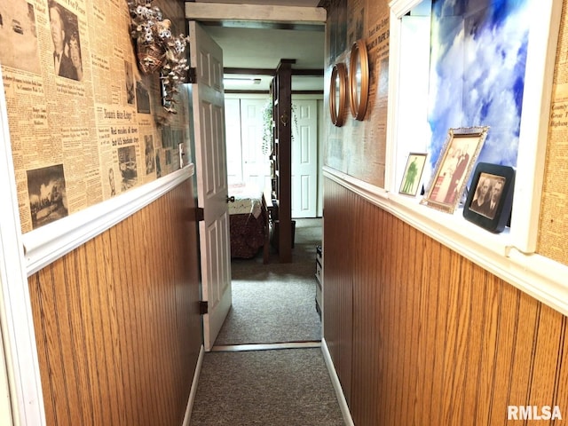 corridor with carpet flooring and wood walls