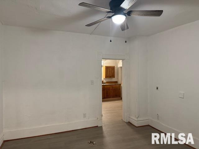 empty room with ceiling fan and hardwood / wood-style flooring