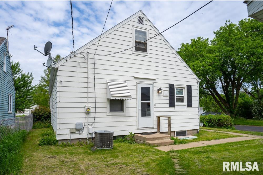 rear view of house with a yard and cooling unit