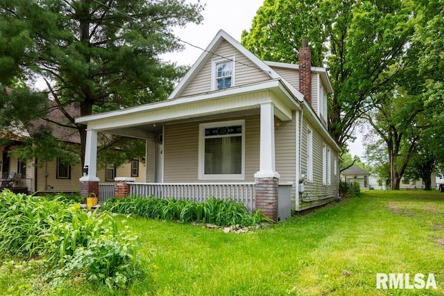 view of front facade featuring covered porch and a front yard