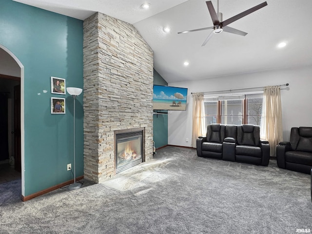 carpeted living room with ceiling fan, a fireplace, and high vaulted ceiling