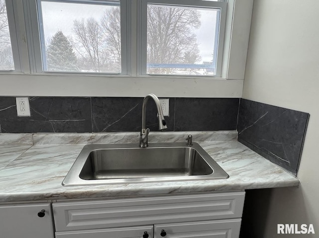 interior details featuring white cabinetry and sink