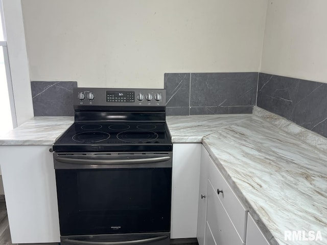 kitchen with white cabinetry and stainless steel range with electric stovetop