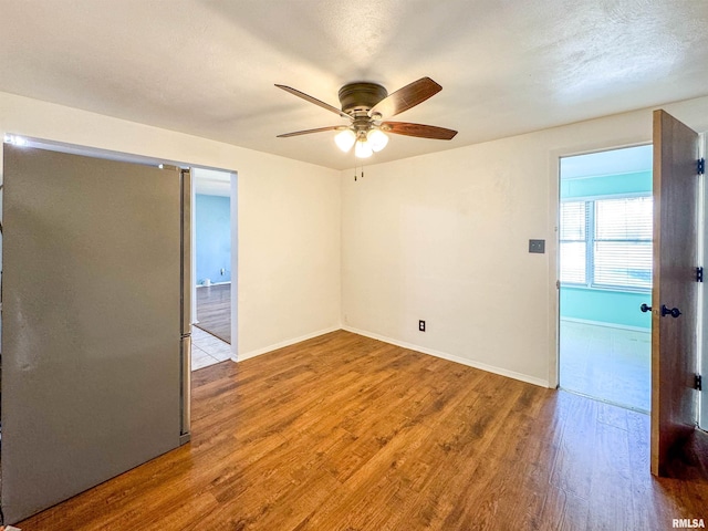 unfurnished room with ceiling fan, hardwood / wood-style floors, and a textured ceiling