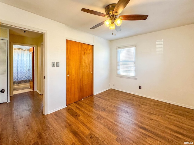 unfurnished bedroom with ceiling fan, dark hardwood / wood-style flooring, and a closet