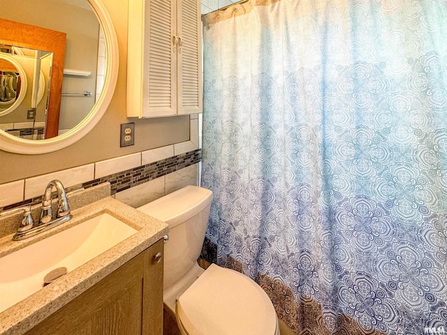 bathroom featuring decorative backsplash, vanity, toilet, and tile walls