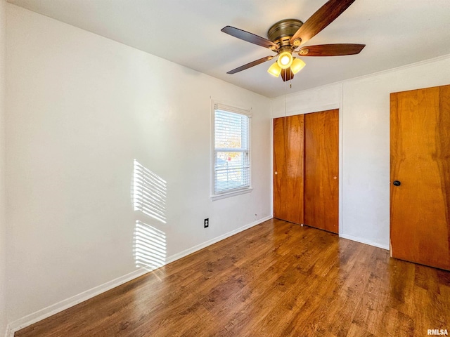 unfurnished bedroom featuring ceiling fan, dark wood-type flooring, and a closet