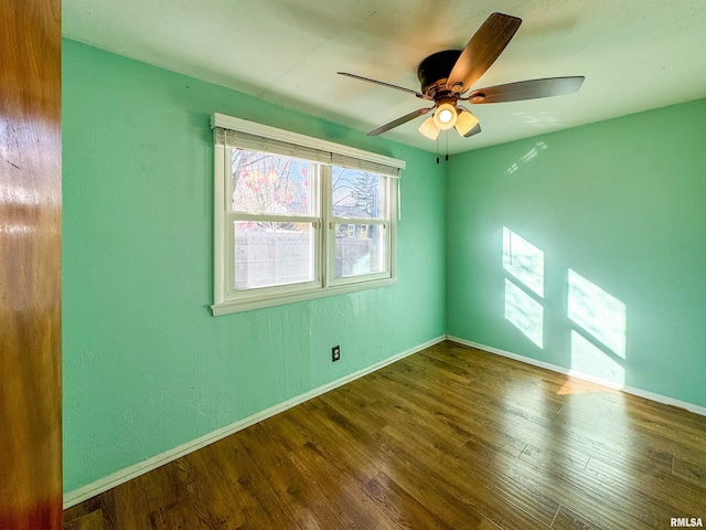 spare room featuring ceiling fan and dark hardwood / wood-style flooring