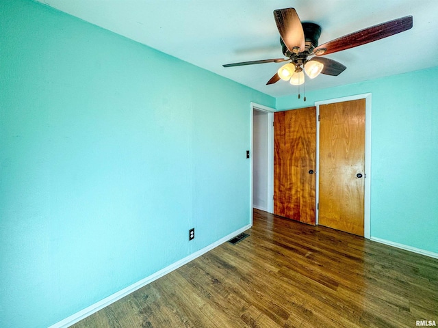 unfurnished bedroom featuring ceiling fan and dark wood-type flooring