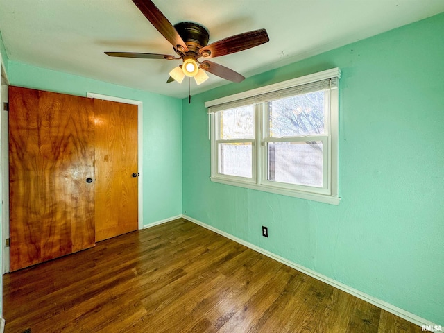 unfurnished bedroom featuring ceiling fan, dark hardwood / wood-style flooring, and a closet