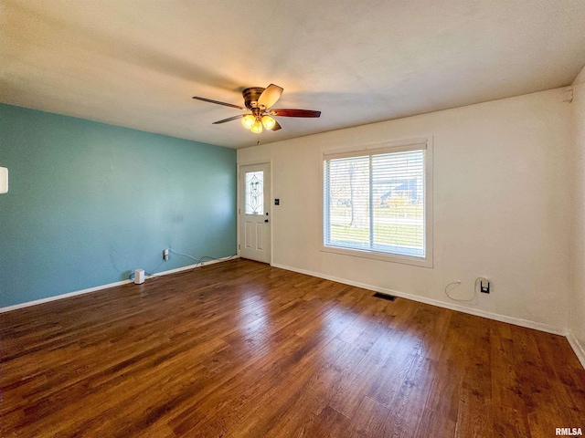 empty room with ceiling fan and dark wood-type flooring