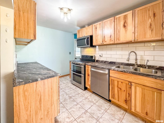 kitchen featuring backsplash, sink, light tile patterned floors, and stainless steel appliances