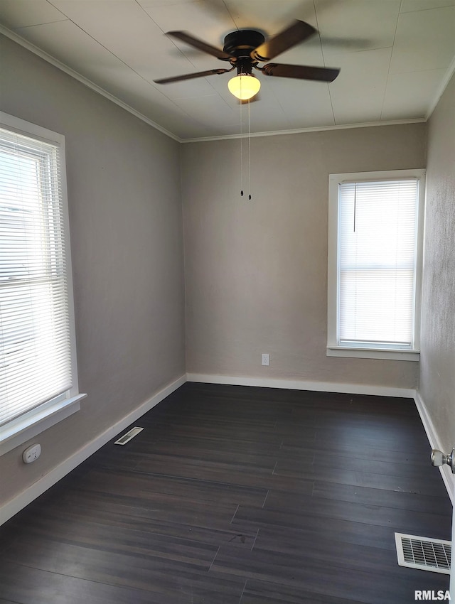 empty room with ceiling fan, a healthy amount of sunlight, and dark hardwood / wood-style flooring