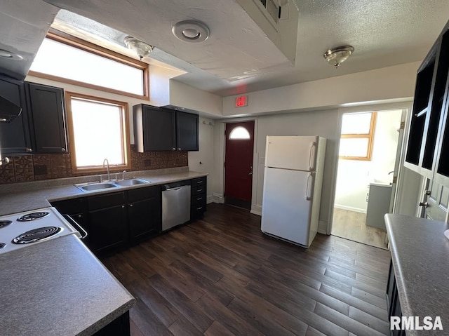 kitchen with dark hardwood / wood-style flooring, a healthy amount of sunlight, sink, white refrigerator, and dishwasher