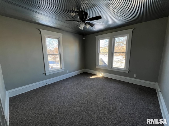 carpeted empty room with ceiling fan and plenty of natural light