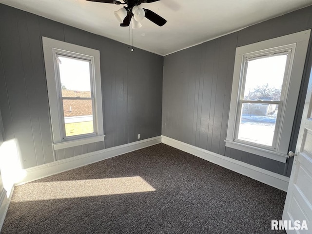 carpeted spare room featuring ceiling fan