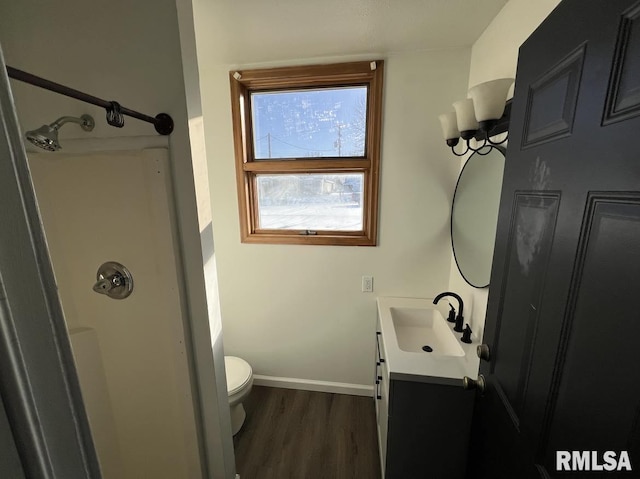 bathroom with a shower, toilet, vanity, and hardwood / wood-style flooring