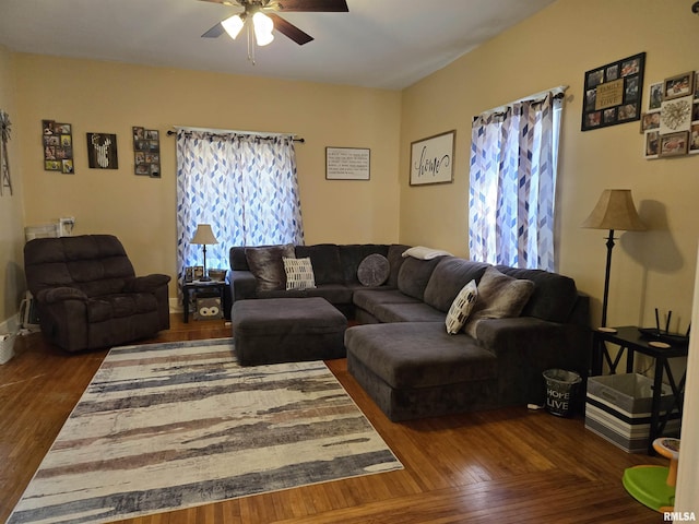 living room featuring ceiling fan and dark hardwood / wood-style flooring