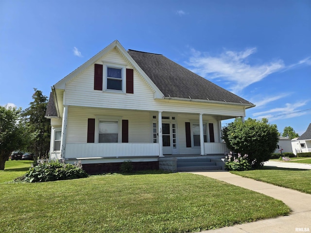 505 W Main St, La Harpe, IL 61450 - view of front facade featuring a porch, a front lawn, and a shingled roof