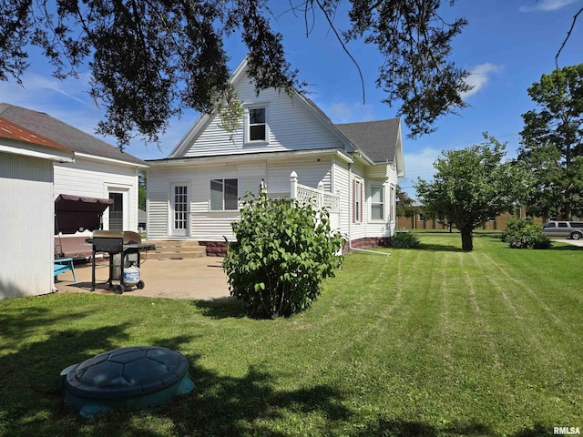 505 W Main St, La Harpe, IL 61450 - rear view of property featuring a patio, a yard, a shingled roof, and entry steps