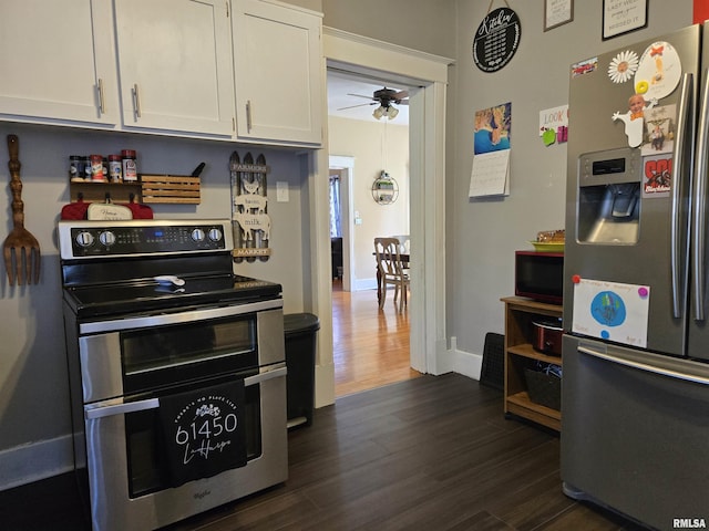 505 W Main St, La Harpe, IL 61450 - kitchen with stainless steel appliances, dark wood-style floors, a ceiling fan, and white cabinetry