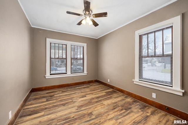 empty room with ceiling fan, dark wood-type flooring, and ornamental molding