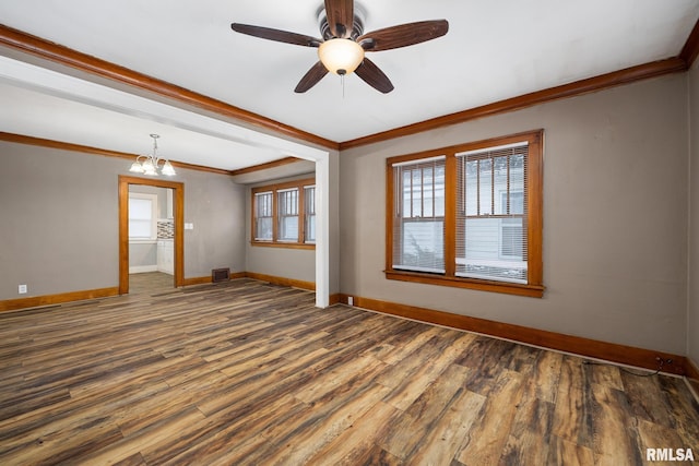 spare room with crown molding, dark wood-type flooring, and ceiling fan with notable chandelier