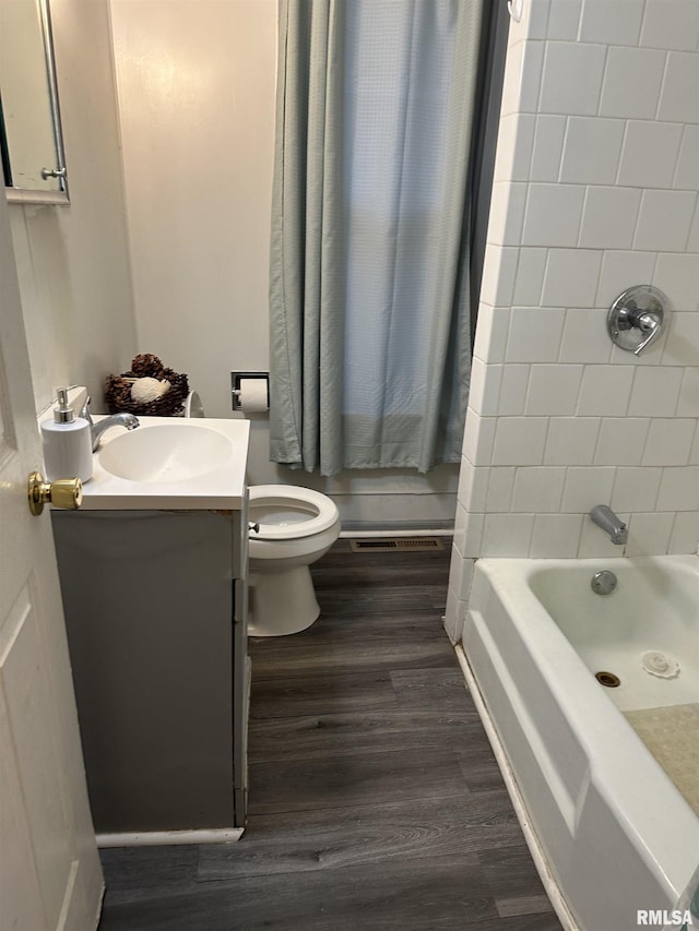bathroom featuring shower / tub combo, vanity, toilet, and wood finished floors