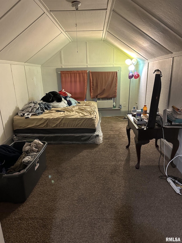 bedroom featuring a decorative wall, vaulted ceiling, and carpet floors