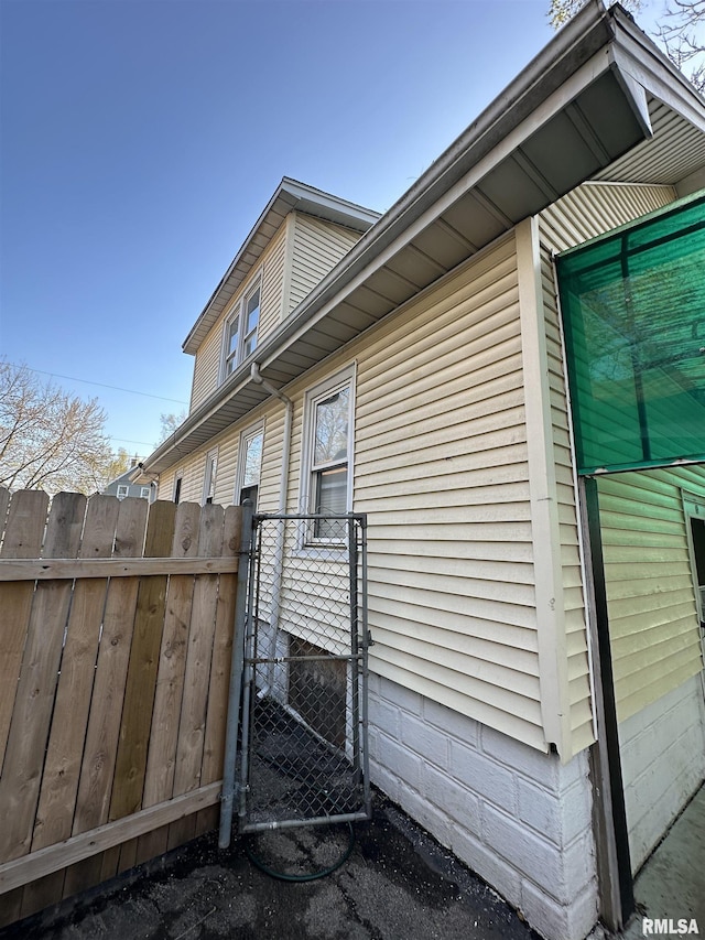 view of home's exterior featuring fence and a gate