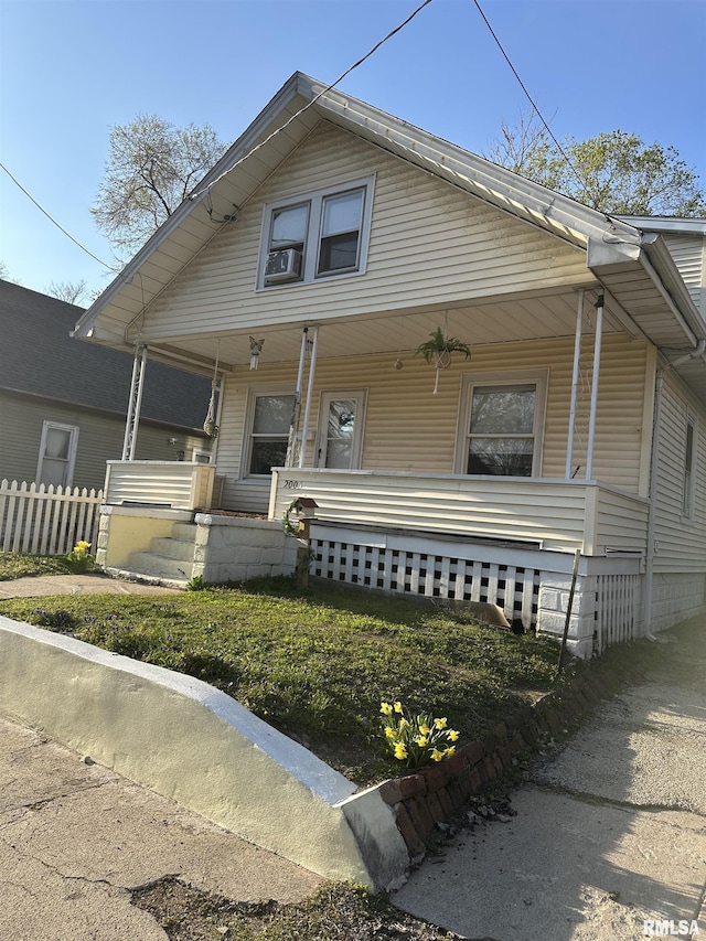 bungalow featuring a porch and fence