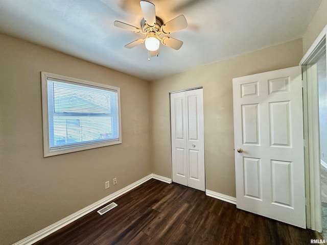 unfurnished bedroom featuring a closet, ceiling fan, and dark wood-type flooring