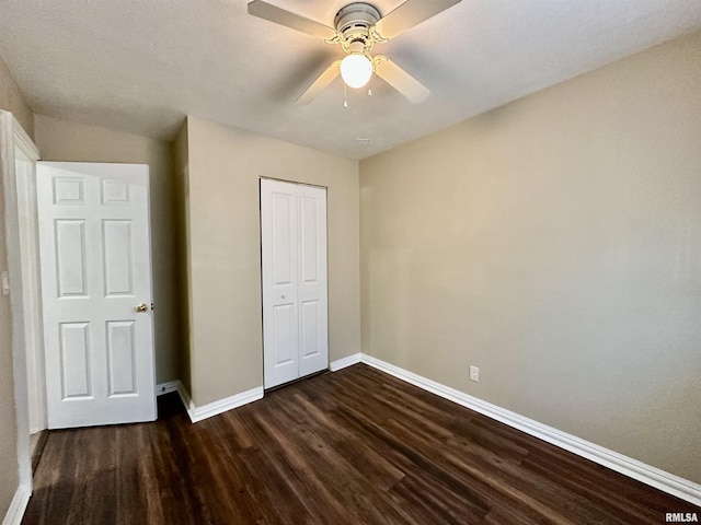 unfurnished bedroom featuring a closet, ceiling fan, and dark hardwood / wood-style floors