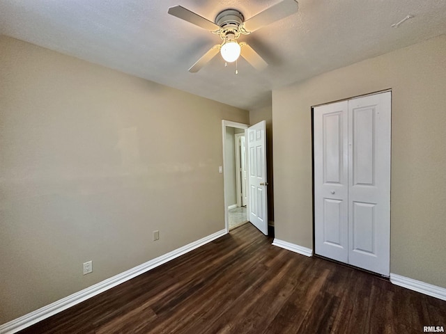 unfurnished bedroom with a closet, ceiling fan, and dark wood-type flooring