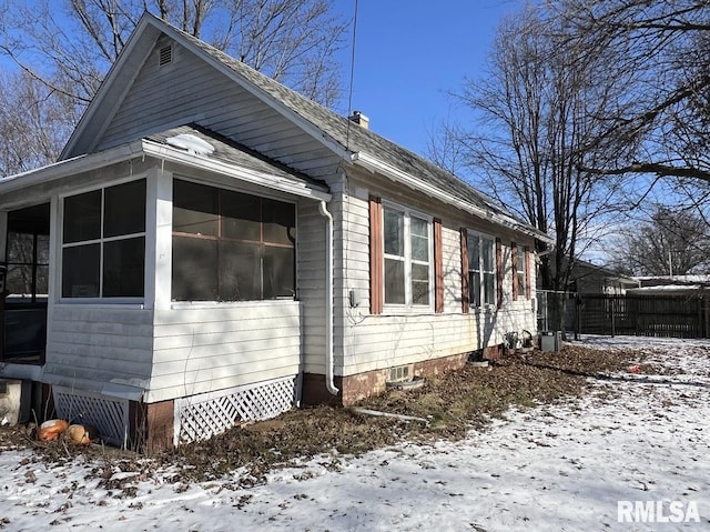 view of snow covered exterior with a sunroom