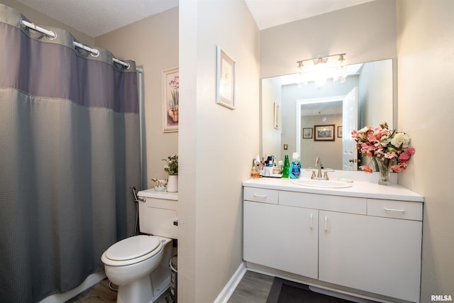 bathroom with hardwood / wood-style floors, vanity, toilet, and walk in shower