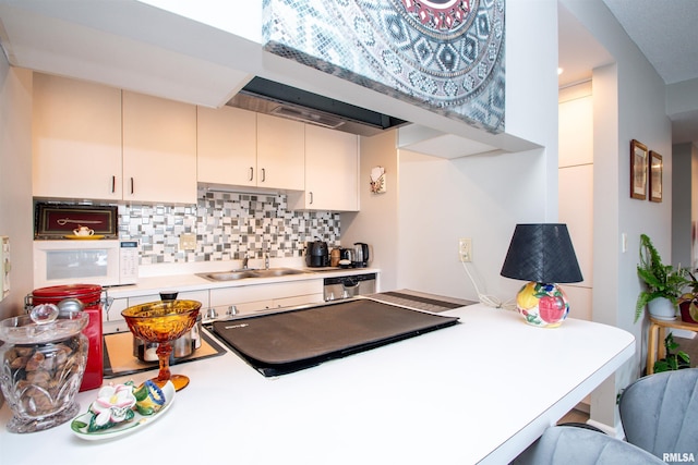 kitchen featuring decorative backsplash, kitchen peninsula, and sink