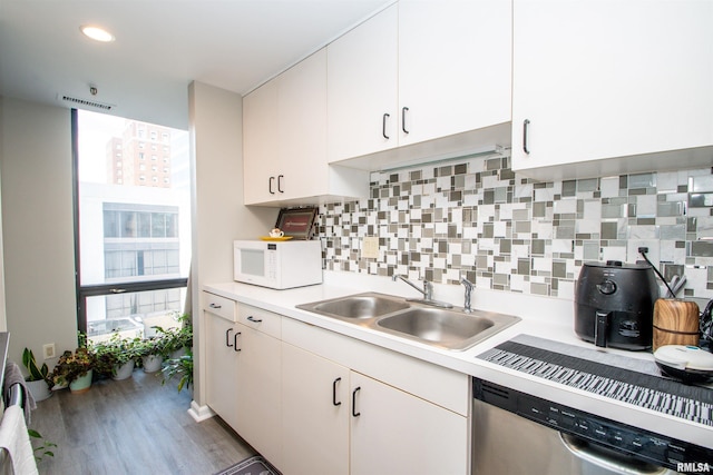 kitchen featuring white cabinetry, decorative backsplash, sink, and stainless steel dishwasher