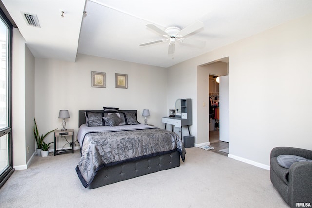 carpeted bedroom featuring ceiling fan, a walk in closet, and a closet