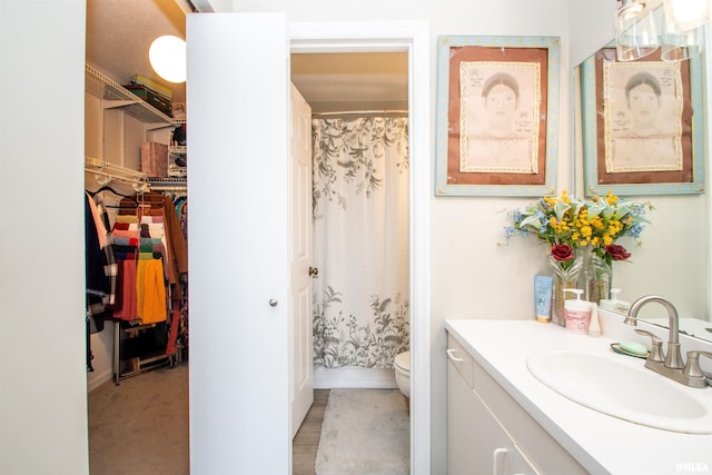 bathroom with a shower with curtain, vanity, and toilet