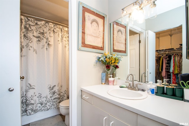 bathroom with a shower with shower curtain, vanity, and toilet