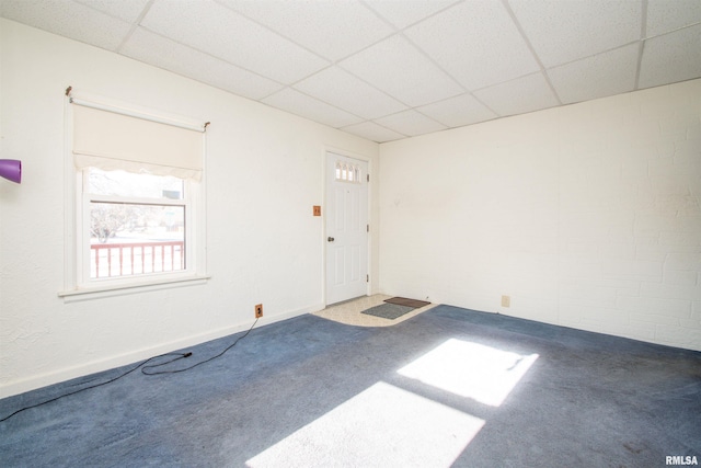 carpeted spare room with a drop ceiling