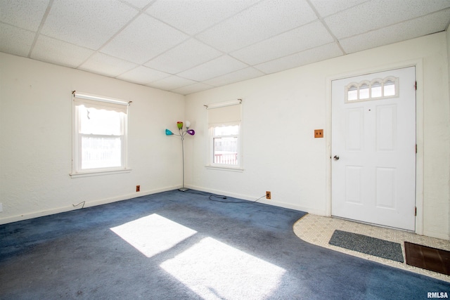 carpeted foyer with a paneled ceiling