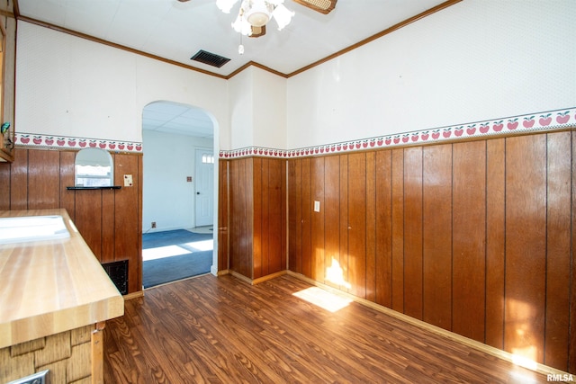 interior space featuring dark hardwood / wood-style floors, ceiling fan, and crown molding