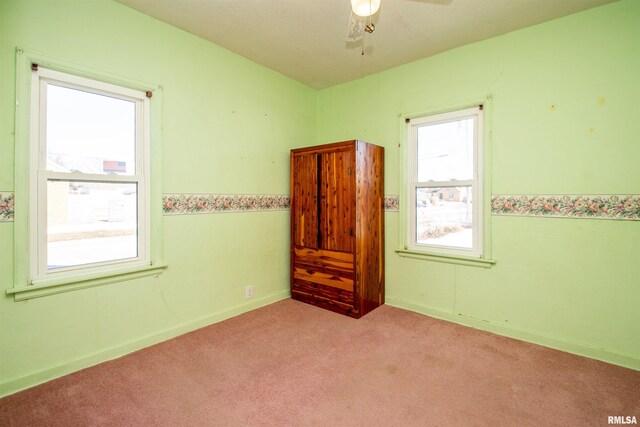 empty room featuring light colored carpet and ceiling fan