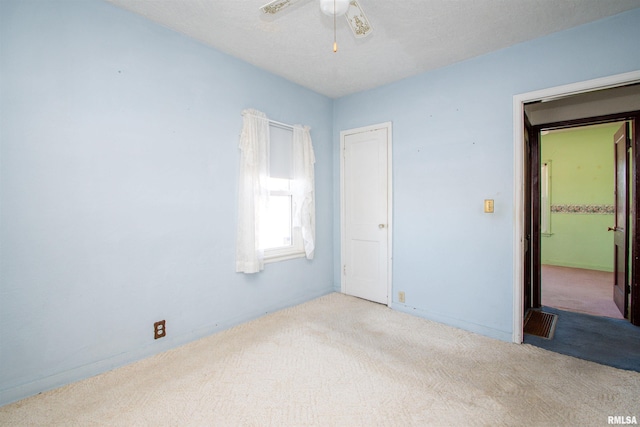 empty room featuring ceiling fan and light colored carpet