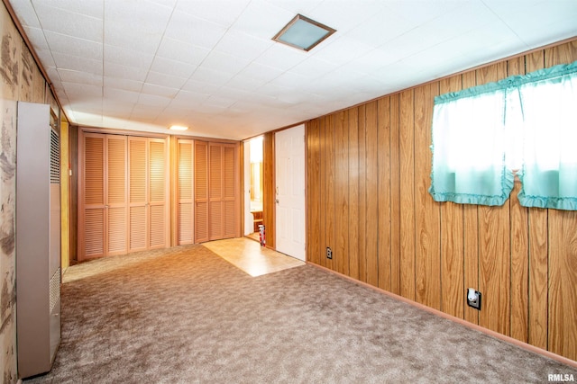 spare room with carpet floors and wooden walls