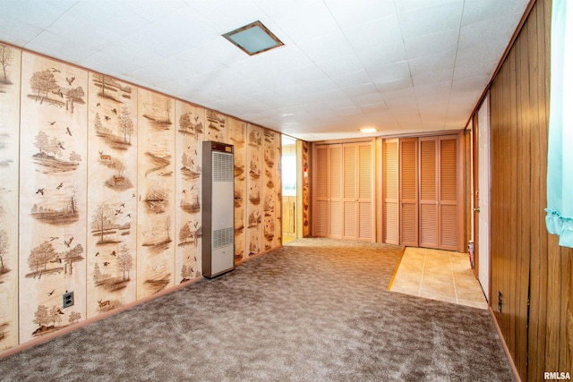 spare room with carpet and wooden walls