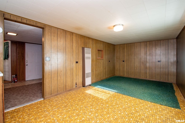 empty room with carpet flooring and wood walls