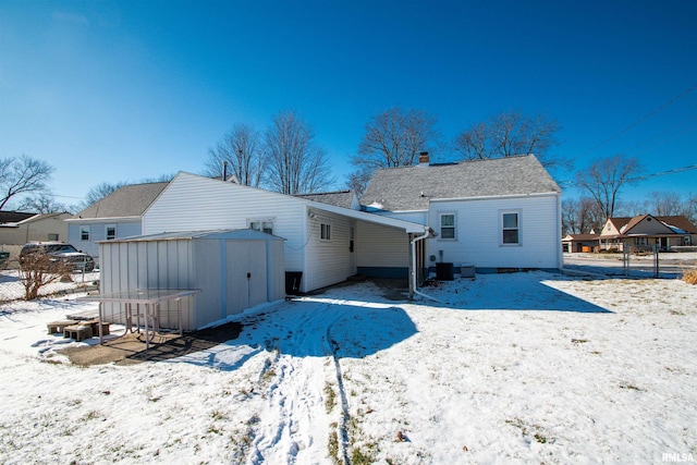 snow covered house with a storage unit